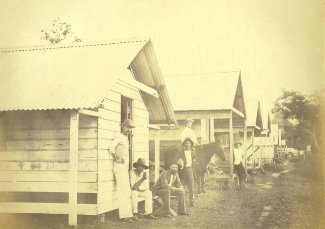 Six wooden accommodation buildings with six men and horse in permanent Camp at Kamerunga on the Cairns railway in 1888