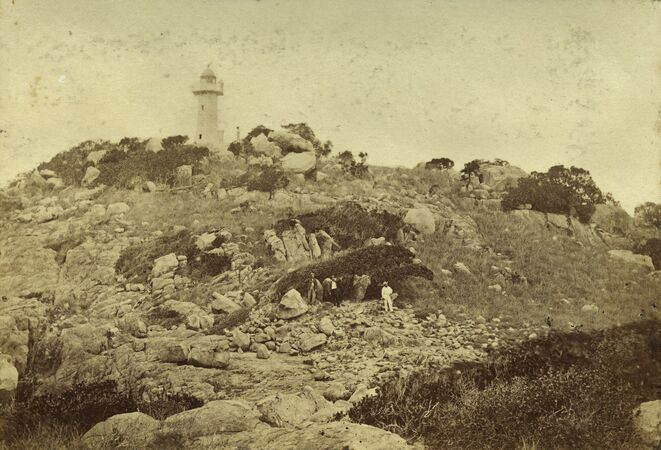 Lighthouse with rocky slope in foreground, sepia tint