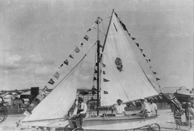 People riding on sailboat in street procession
