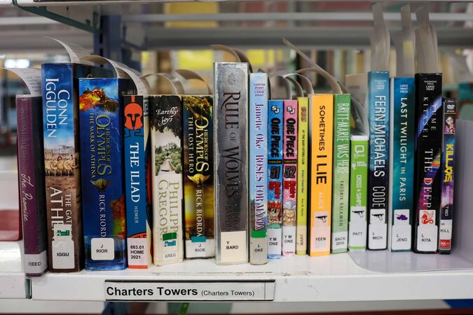 Books on a shelf labelled Charters Towers