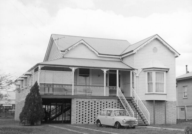 Queenslander house in black and white with small car out front
