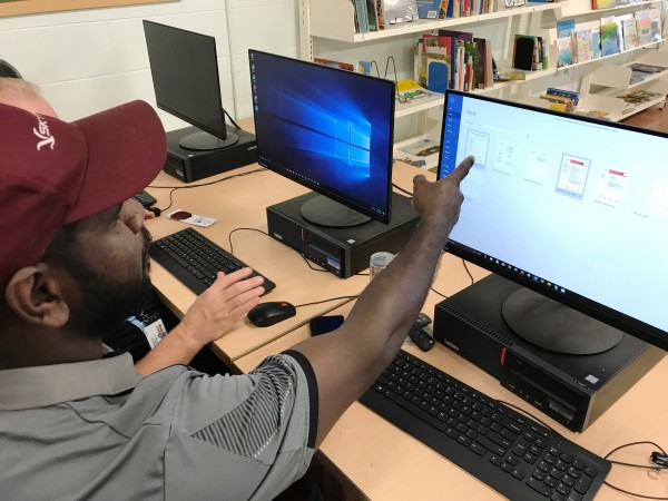 A man points at the computer screen during training