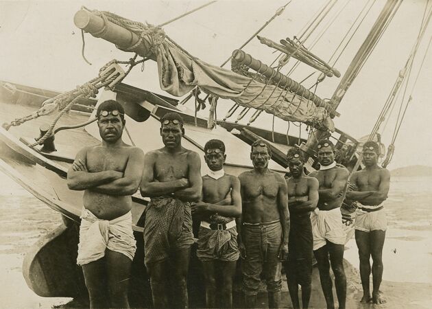 Pearl divers standing in front of their boat in the Torres Strait, 1920