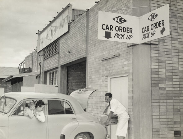 Supermarket worker loading groceries into a car boot at the Cash and Carry pick up entrance at Chermside, 1957