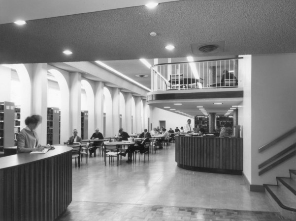 Old photo of the interior of the State Library of Queensland main reading room and information counter.