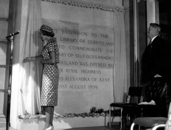  Princess Alexandra wearing a polka dot dress with a short jacket and hat made from the same material unveils a plaque to officially open the extension to the Public Library of Queensland later the State Library Queenslands Premier George Francis Reuben Frank Nicklin observes the ceremony from one side of the commemorative plaque