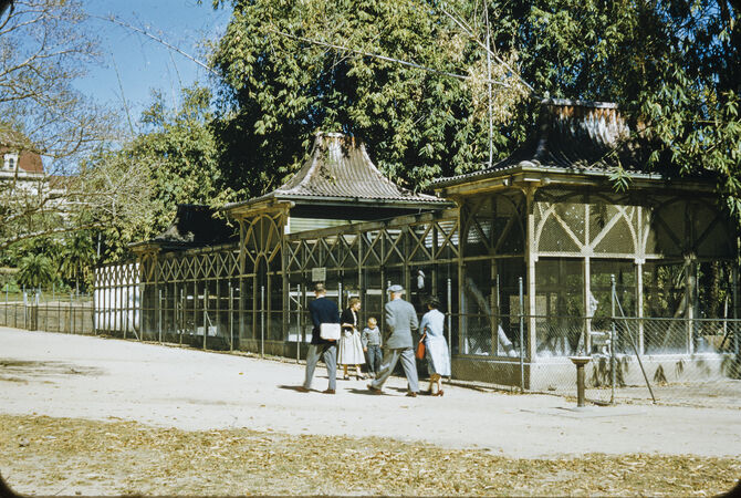 People walking next to the aviaries in the Brisbane Botanic Gardens in 1956