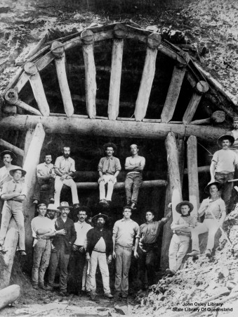 Workers line up for the photographer with a railway tunnel entrance on display