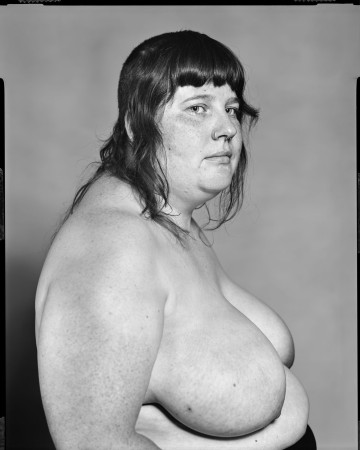 Black and white portrait of the left view of a shirtless person.