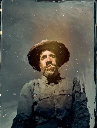 Distorted photograph of man wearing a hat.