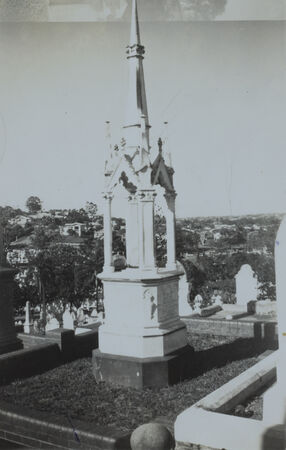 A monument rising above surrounding gravestones in a cemetery