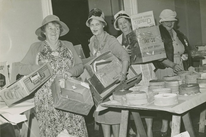 Women from the Queensland Country Women's Association unpacking cakes entered in a cookery competition, 1962.