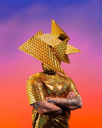 Photograph of person wearing a sparkling gold outfit with an abstract head covering.