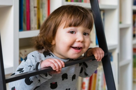 Child at the library in front of books