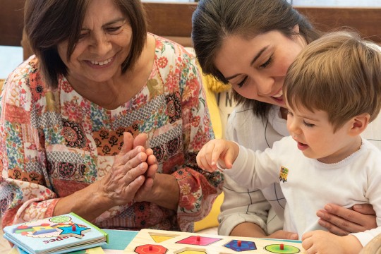 Family share puzzle with toddler.