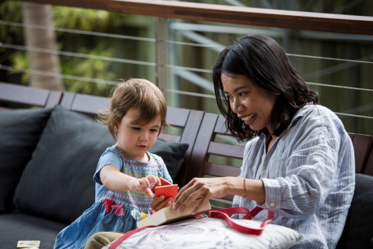 Mother and daughter looking at square tile