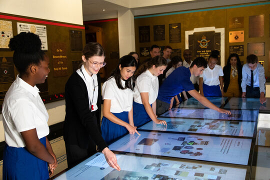 Surge Media. Students engaging with digital interactive screens at Anzac Square Memorial Galleries  