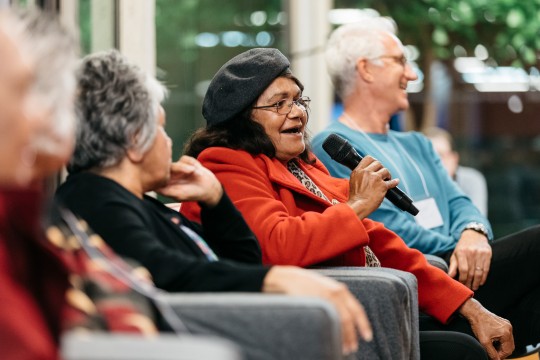 Members of the Cherbourg Marching Girls talking to an audience in kuril dhagun at State Library of Queensland