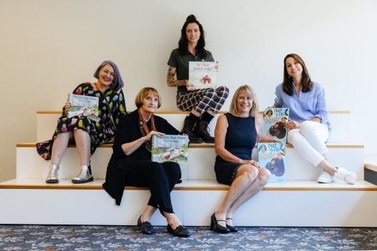 Authors and illustrators holding books they have worked on