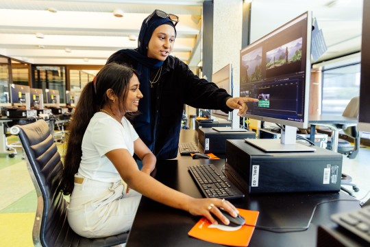 young women use computer in digital media lab