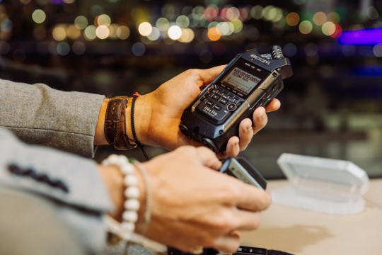 A photo of someone holding a zoom audio recorder