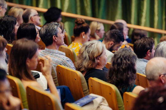 Audience seated in auditorium seats.