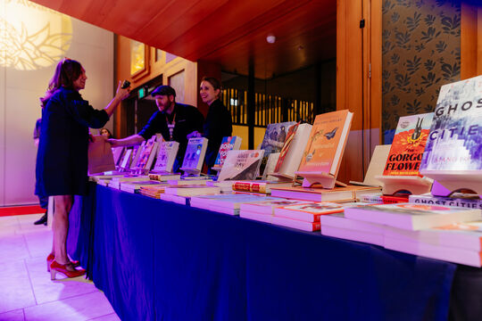 People selling and browsing at a table of books