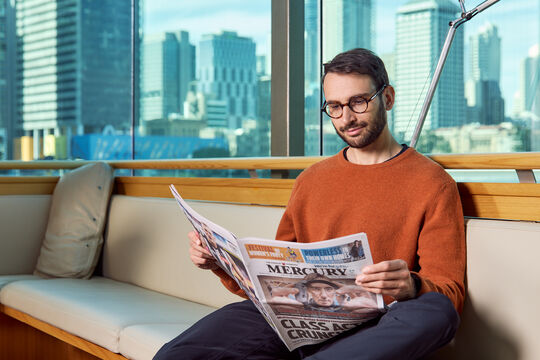 Man reading newspaper at the library