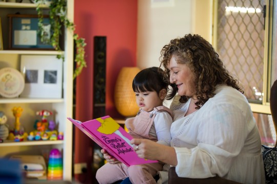 Woman and toddler share book at home 