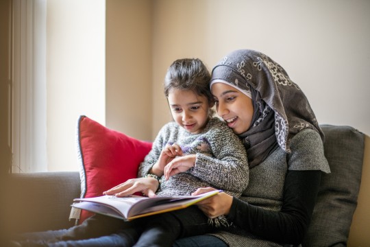 Mother reading with child on her lap