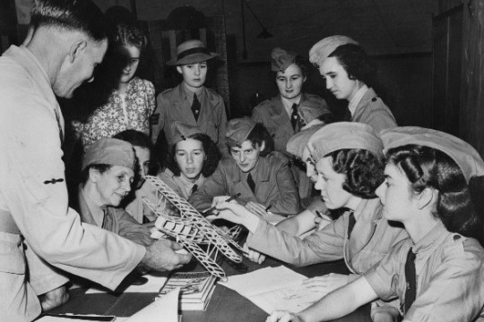 A group of women looking at a model aeroplane