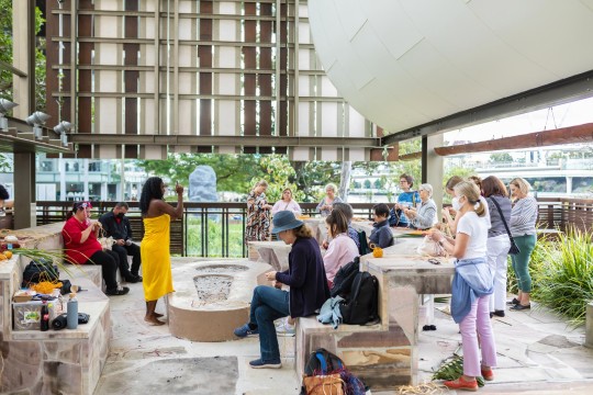 First Nations woman in the State Library Talking Circle instructing a group of people around her.