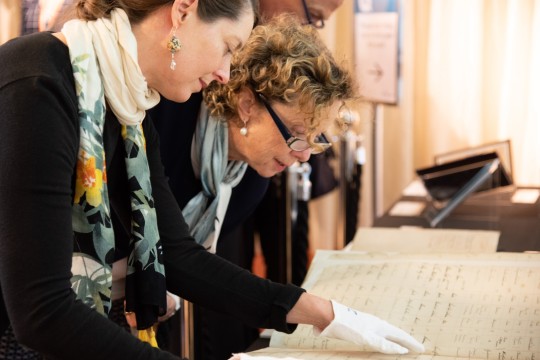 Two women looking at the Synagogue records