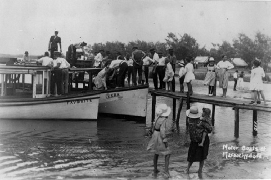 Black  White photo of a group of people getting on board the Favourite and the Vera motor boats at Maroochydore
