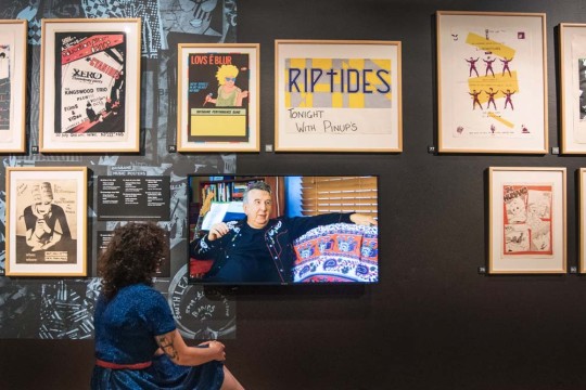 Woman looking at posters in the Cut Copy exhibition