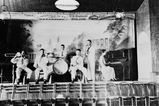 Black and white image of six people playing instruments on a stage at Caboolture ca 1929