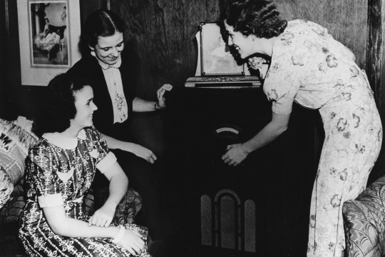 Group of friends gathered around a radio in Brisbane, ca. 1942.