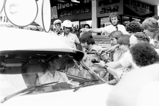 Journalists trying to interview a policeman on Adelaide Street, Brisbane, October 1977.