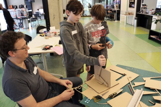 Three people creating cardboard DIY leaver for games
