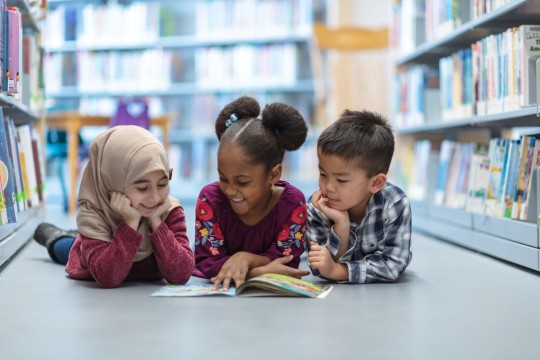 Three Children in Library Aisle