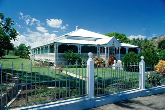 A white house and garden with colourful flowers