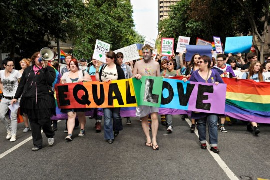 Supporters holding equal love banner on march during Marriage Equality Rally in Brisbane 2011