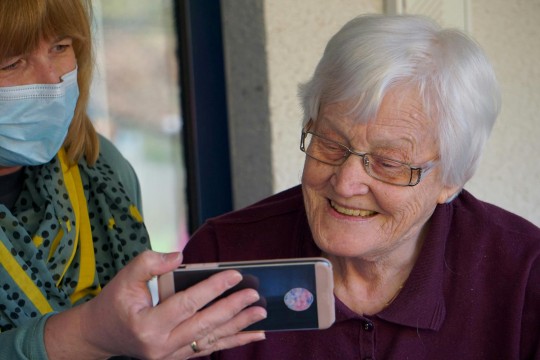 Two women looking at a smart phone.