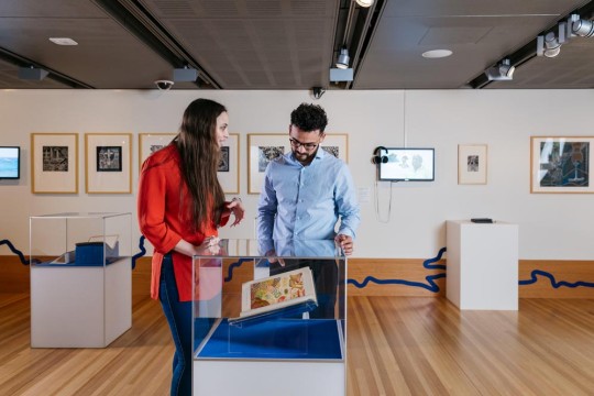 Two people exploring the Islands exhibition