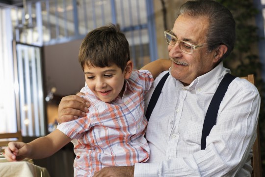 Man with child on his knee, both smiling