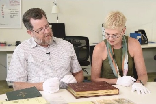 Researchers Matthew Wengert and Louise Martin-Chew explore an item from the collections of the John Oxley Library