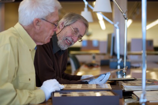Two men looking at collection items in the State Library