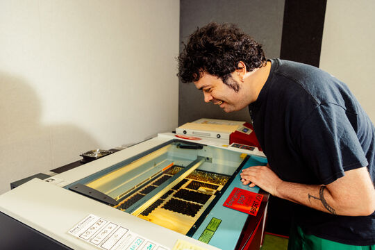 Man looks at laser cutter