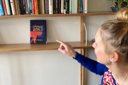 Laura Elvery pointing at Karen Russell's book Orange World
