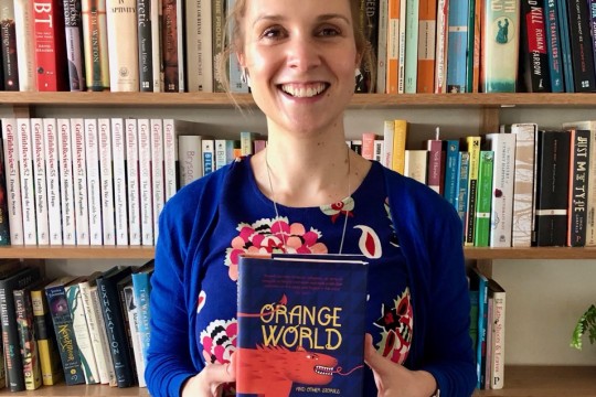 Laura Elvery smiling and holding a copy of Karen Russells book Orange World